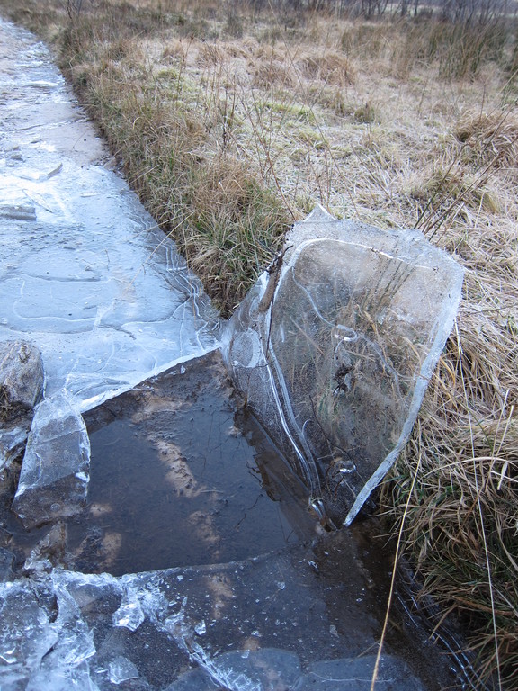 Water puddles along the track at Glen Elchaig had iced over in sub-zero temperatures. John broke a piece of ice to show the thickness 
